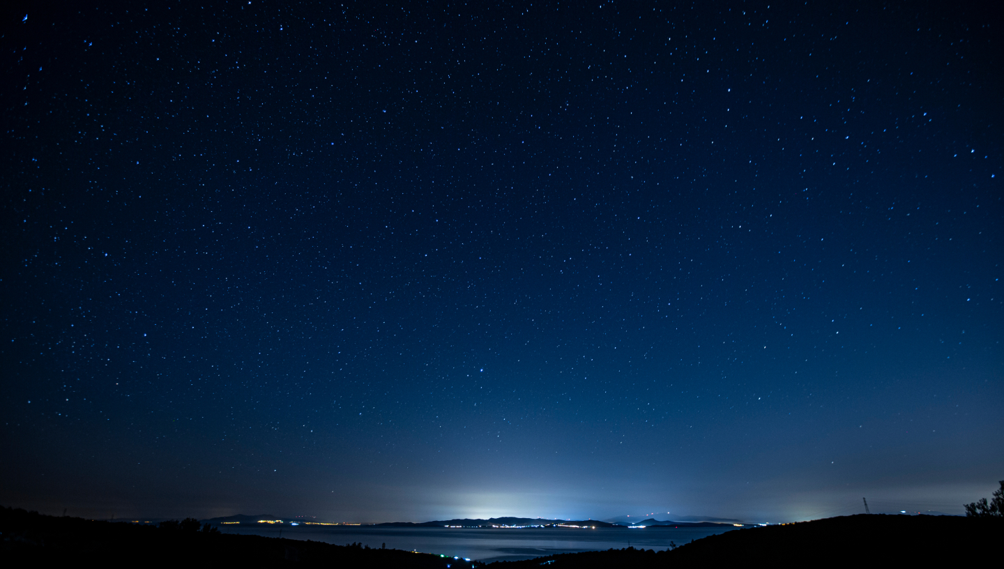 Nattehimmel full av stjerner med vakker utsikt over vann og natur