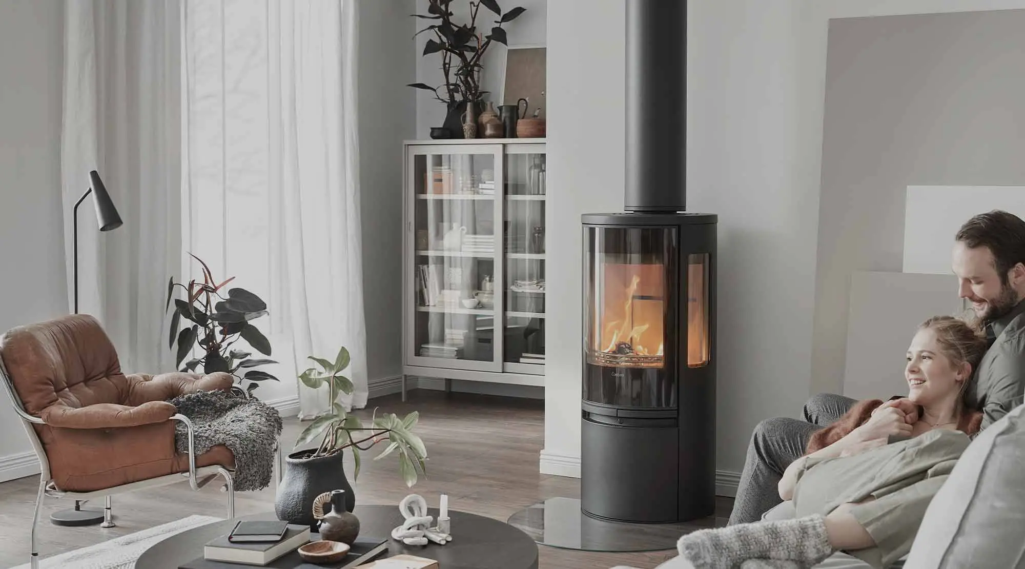 Contura Connect 556 installed in a scandinavian living room with couple on the sofa.